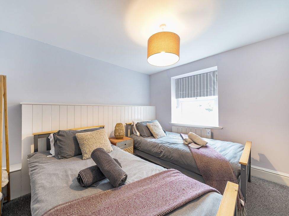 A bedroom with two beds and a window at Ty Mawr, Great Orme in Llandudno