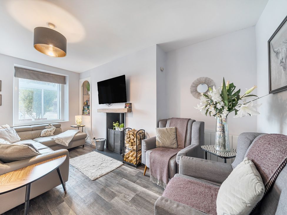 A living room with a sofa and television at Ty Mawr, Great Orme in Llandudno