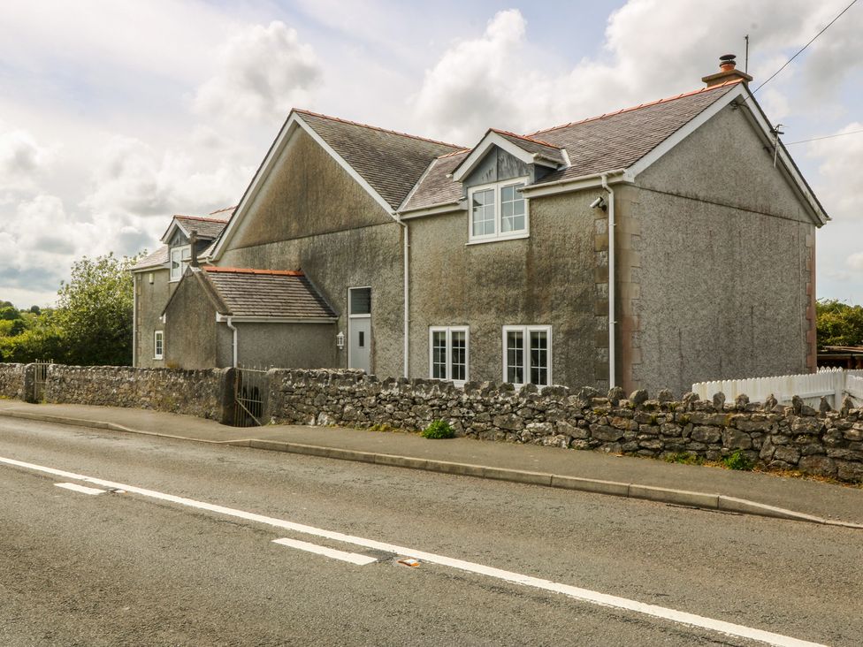 A house with windows and a fence on the roadside at Llanallgo Church Rooms