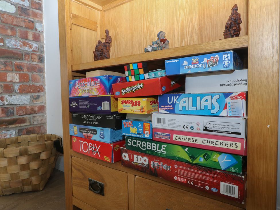 A bookshelf with board games and figurines at Llanallgo Church Rooms