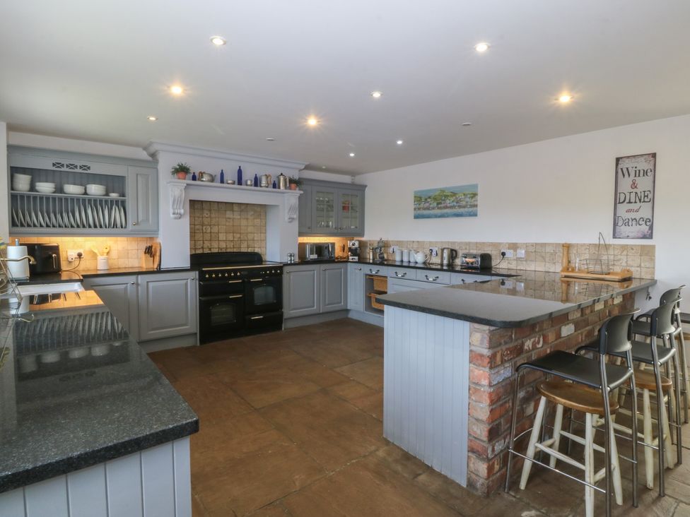 A kitchen with cabinets and appliances at Llanallgo Church Rooms