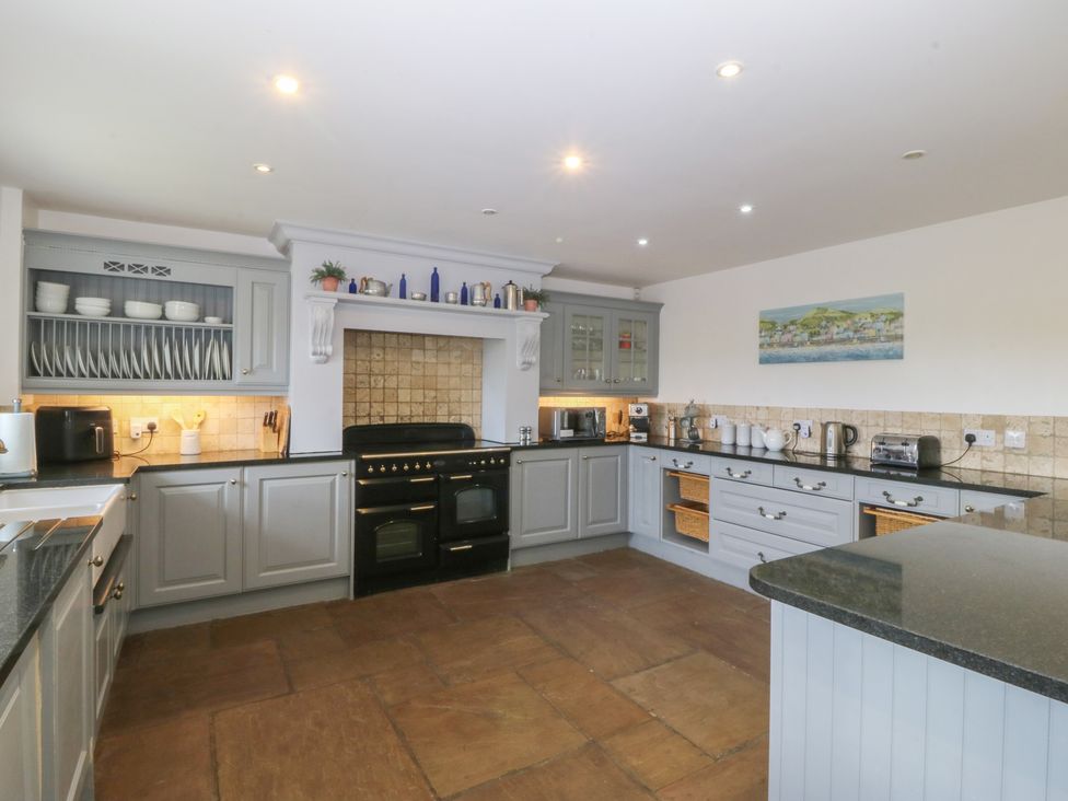 A kitchen with cabinets, oven, and various appliances at Llanallgo Church Rooms