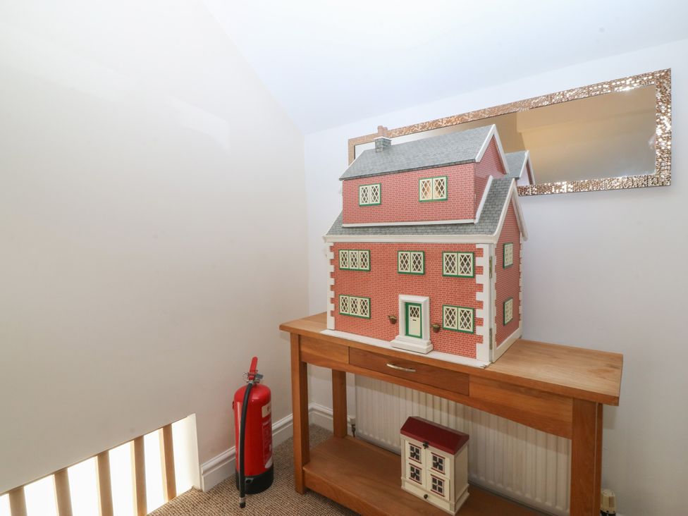 A nook with a dollhouse and table at Llanallgo Church Rooms
