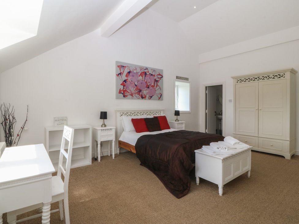 A bedroom with a bed and furniture at Llanallgo Church Rooms