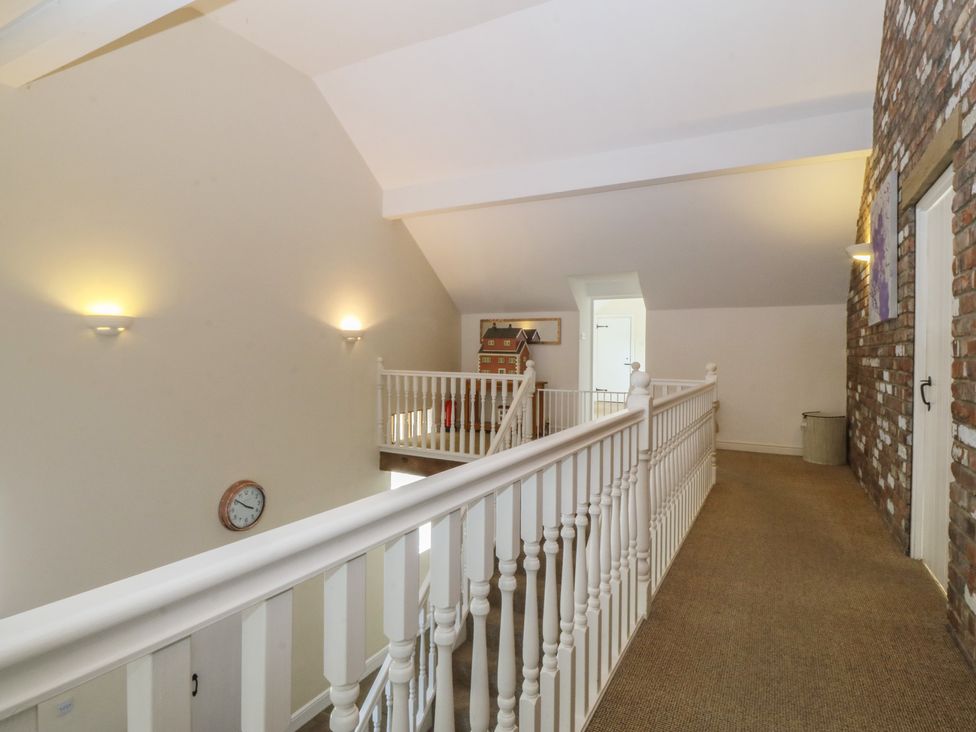 A hallway with a handrail and clock at Llanallgo Church Rooms