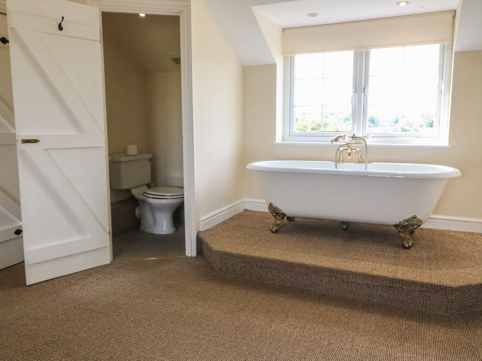 A bathroom with a bathtub and toilet at Llanallgo Church Rooms