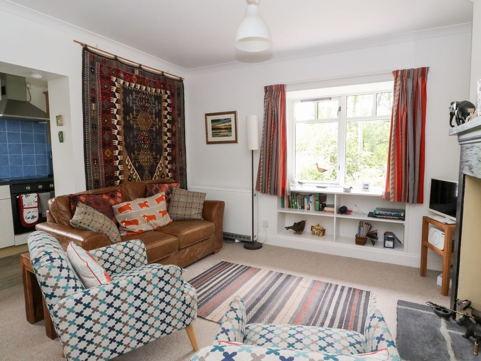 A living room with a sofa and armchair at Tower Lodge in Lochawe