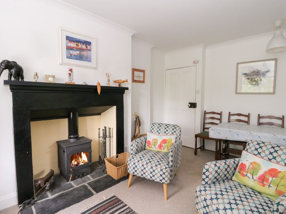 A living room with a fireplace and chairs at Tower Lodge in Lochawe