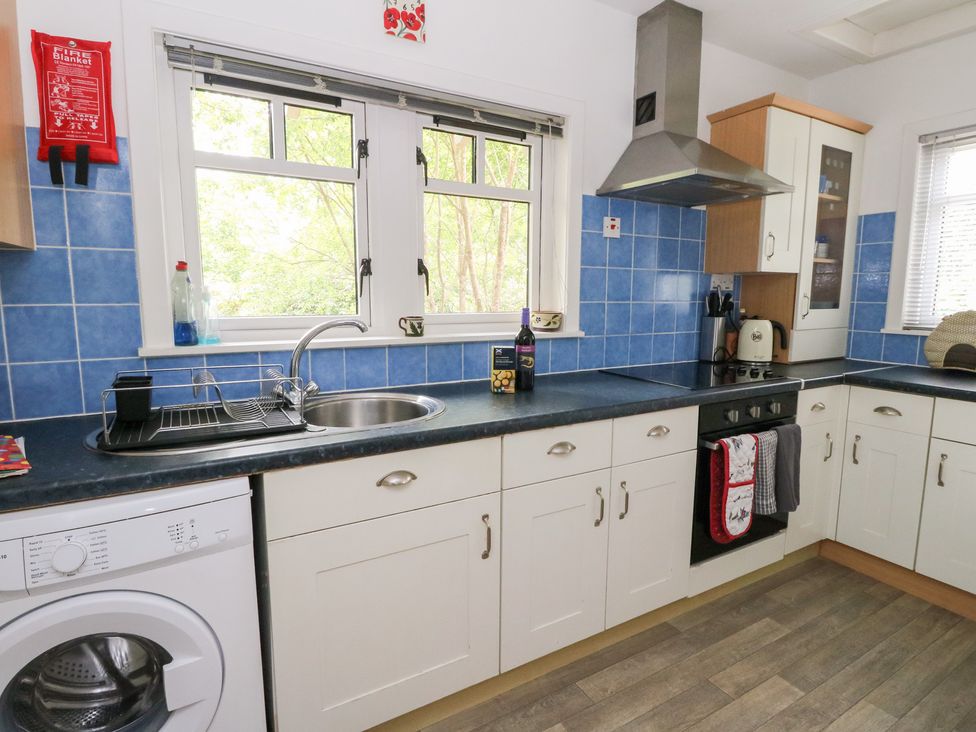 A kitchen with a sink and washing machine at Tower Lodge in Lochawe