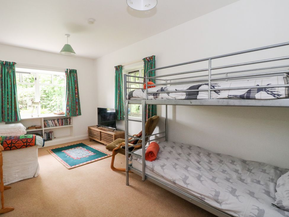 A bedroom with a bunk bed and a television at Tower Lodge in Lochawe