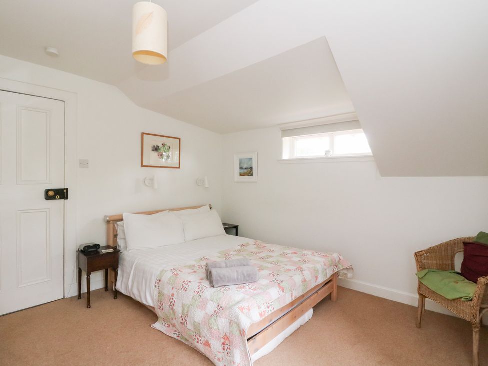 A bedroom with a bed and artworks on the walls at Tower Lodge Lochawe