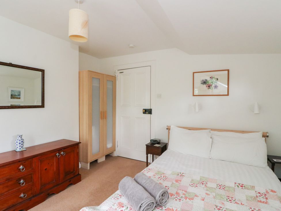 A bedroom with a bed and wardrobe at Tower Lodge in Lochawe