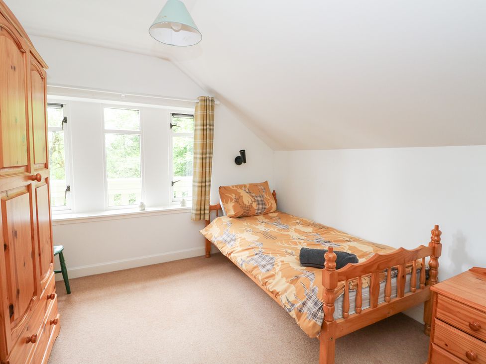 A bedroom with a bed and wardrobe at Tower Lodge in Lochawe