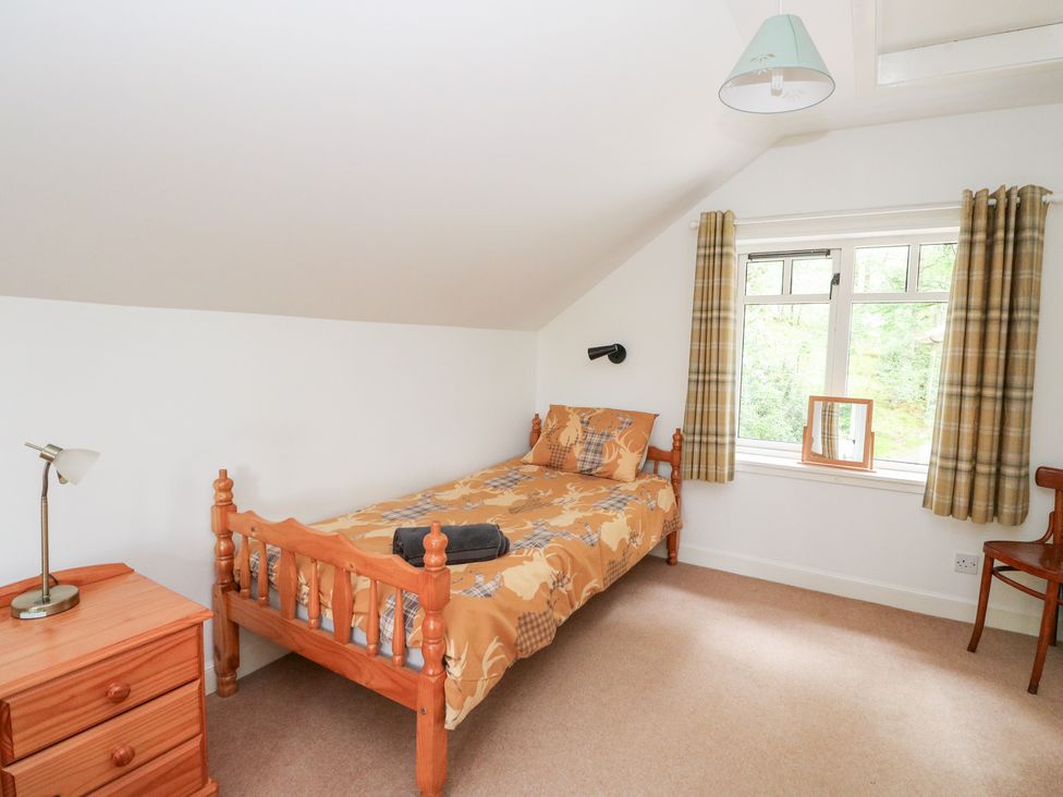A bedroom with a bed and lamp at Tower Lodge in Lochawe