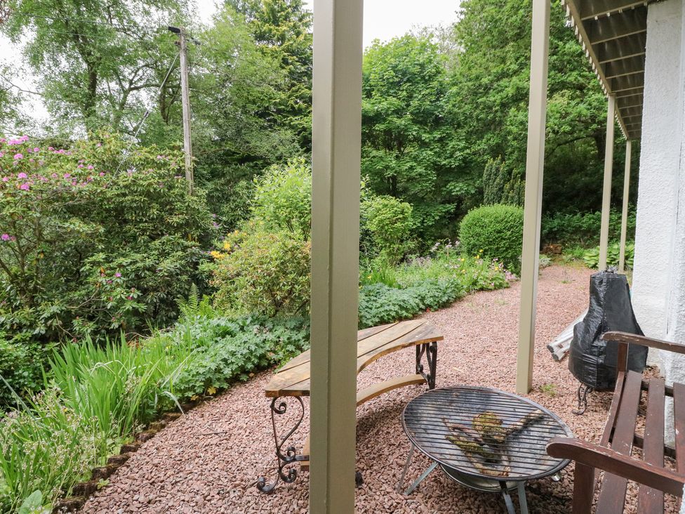 A bench and fire pit in a garden at Tower Lodge in Lochawe