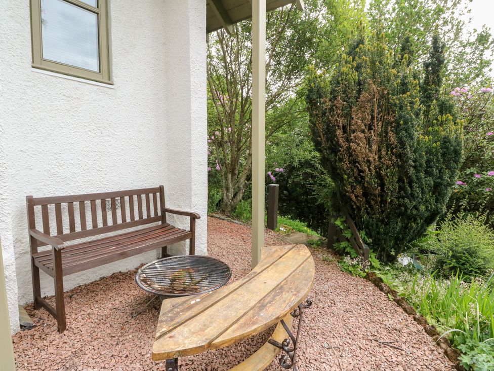 A garden with a bench and fire pit at Tower Lodge in Lochawe