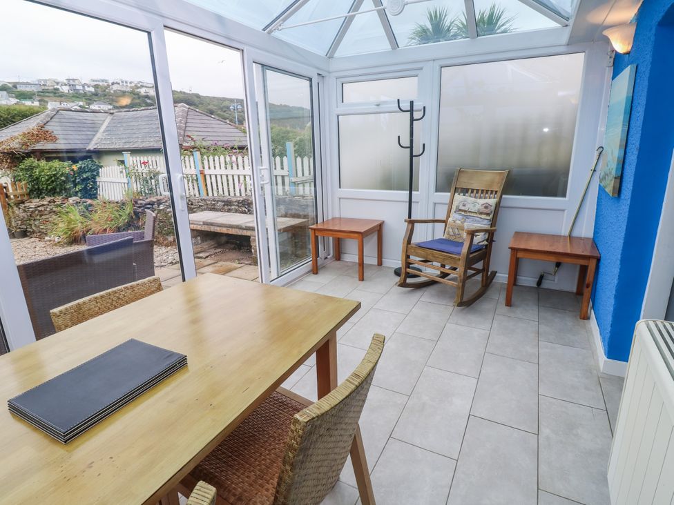 A conservatory with a table and chairs at Pebble Cottage Portreath
