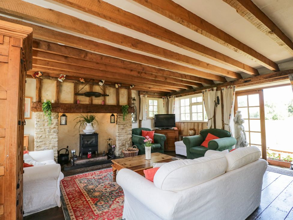 A living room with a fireplace and sofa at Ivy Cottage in Woolverton near Beckington