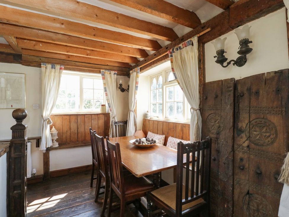 A dining room with a wooden table and chairs at Ivy Cottage Woolverton near Beckington