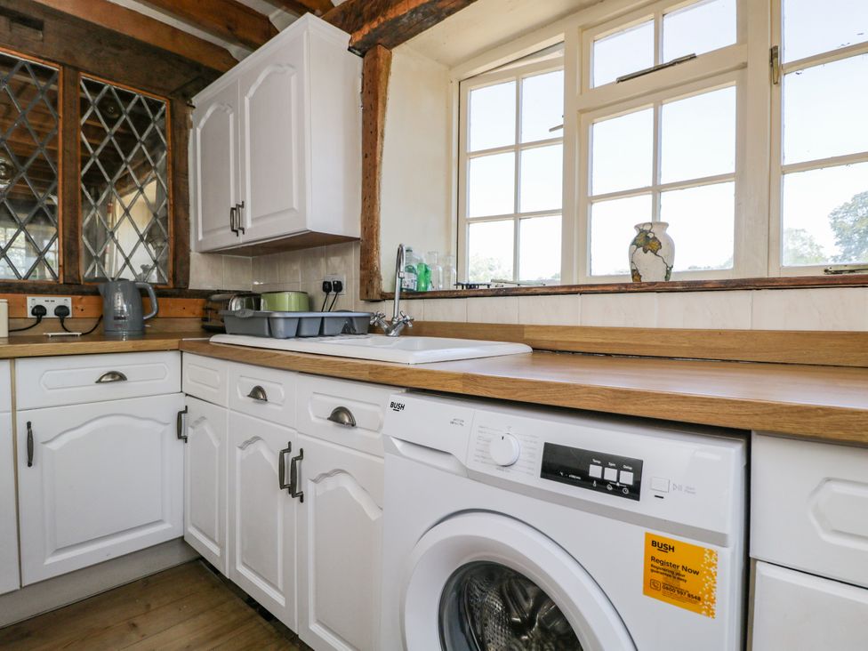 A kitchen with cabinets, sink, and washing machine at Ivy Cottage Woolverton near Beckington