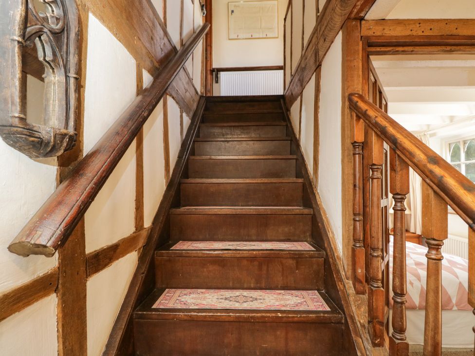 A staircase with wooden walls and a rug at Ivy Cottage in Woolverton near Beckington