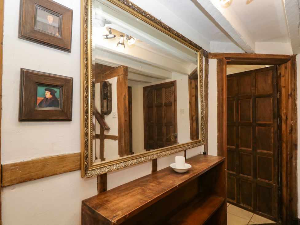 A hallway with a mirror and paintings at Ivy Cottage Woolverton near Beckington