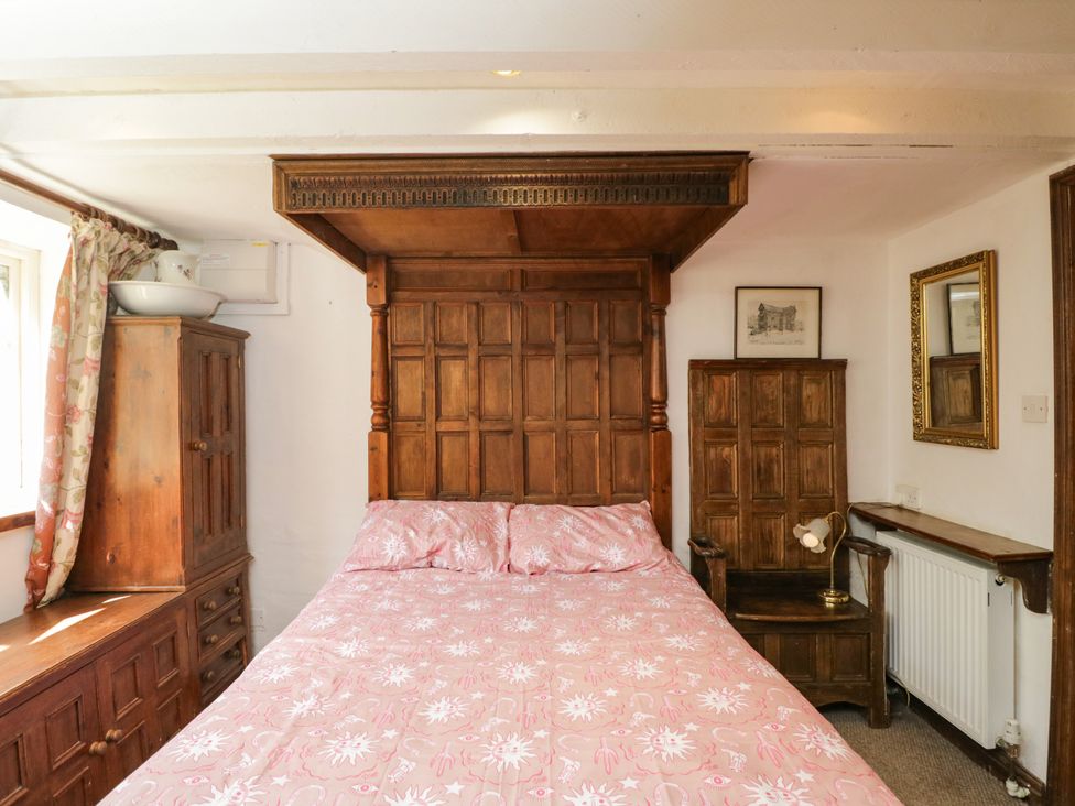 A bedroom with a wooden bed and cabinets at Ivy Cottage in Woolverton near Beckington