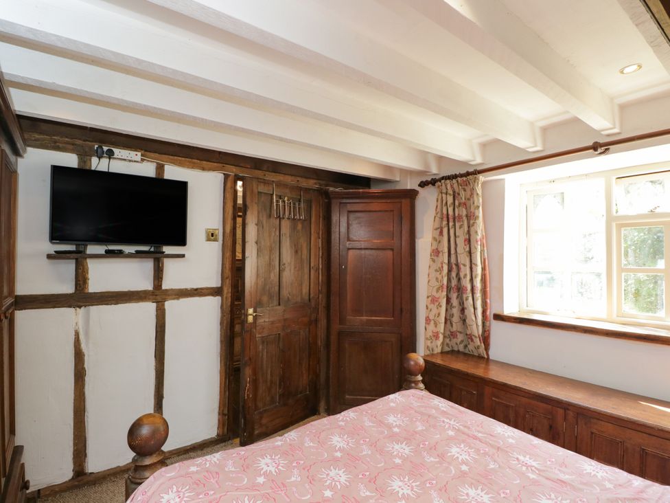 A bedroom with a bed and television at Ivy Cottage in Woolverton near Beckington