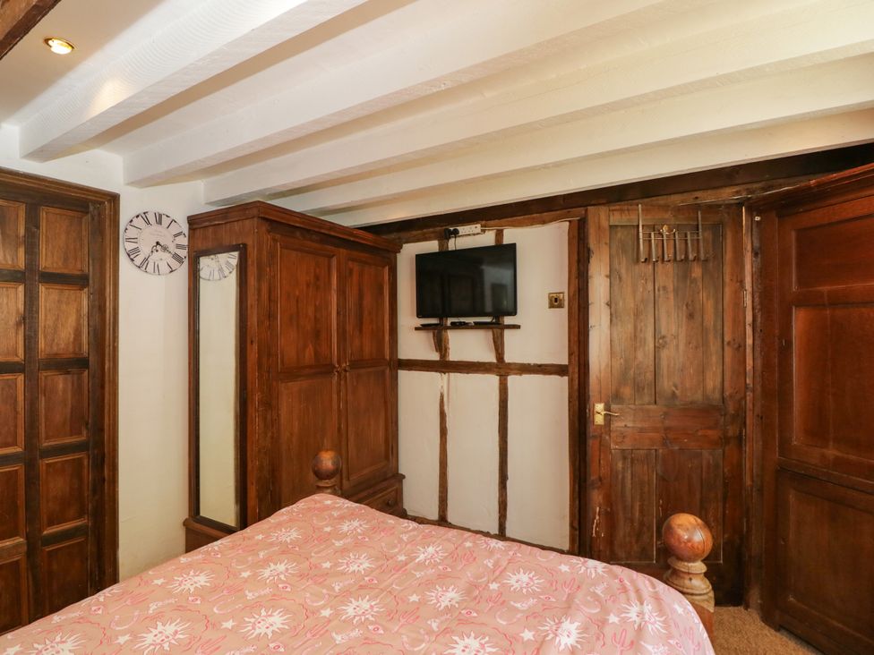 A bedroom with a bed and wardrobe at Ivy Cottage Woolverton near Beckington