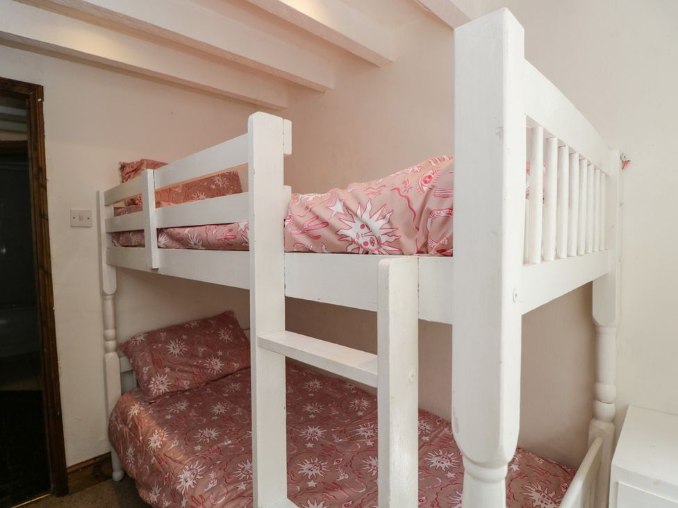 A bunk bed with pink bed linens at Ivy Cottage Woolverton near Beckington