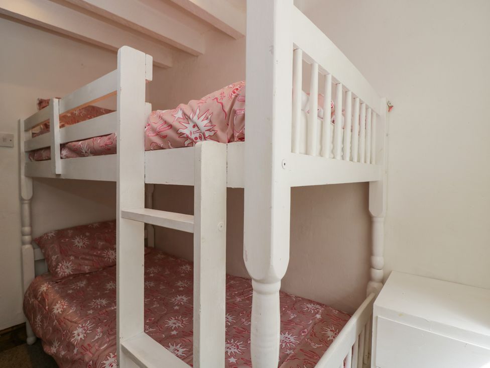 A bunk bed with pink bed linen at Ivy Cottage Woolverton near Beckington