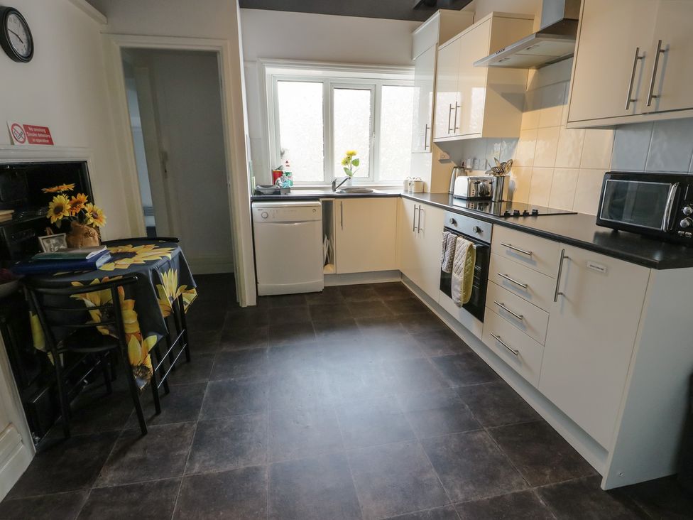 A kitchen with appliances and a table at Sea Breeze in Rhos-on-Sea