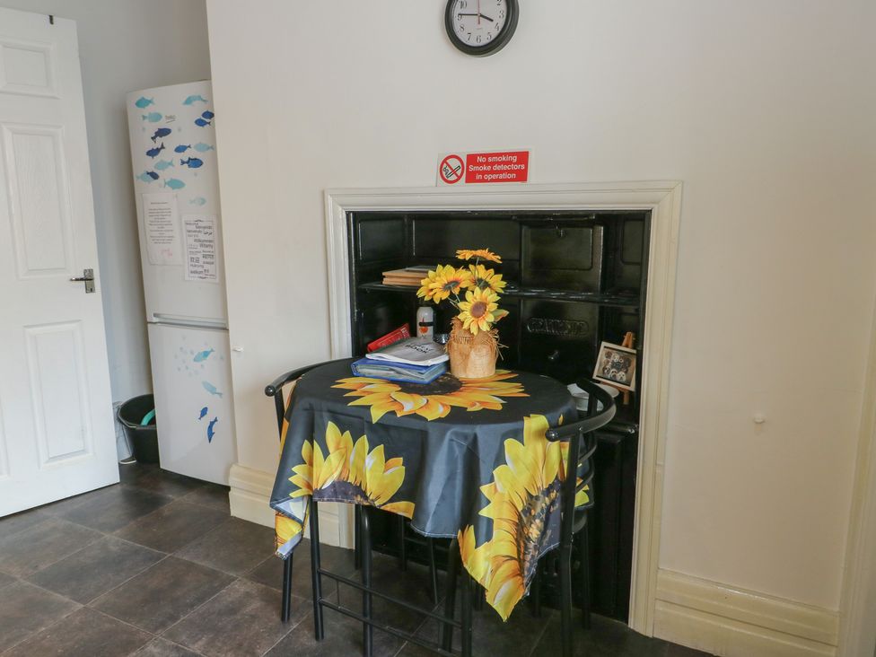 A kitchen with a table and chairs at Sea Breeze in Rhos-on-Sea
