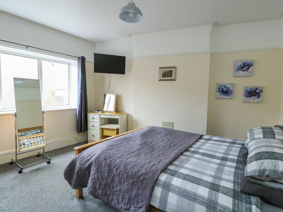 A bedroom with a bed and television at Sea Breeze in Rhos-on-Sea