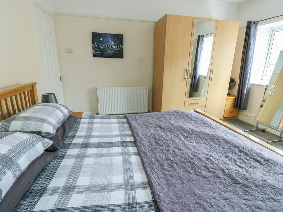 A bedroom with a bed and wardrobe at Sea Breeze in Rhos-on-Sea