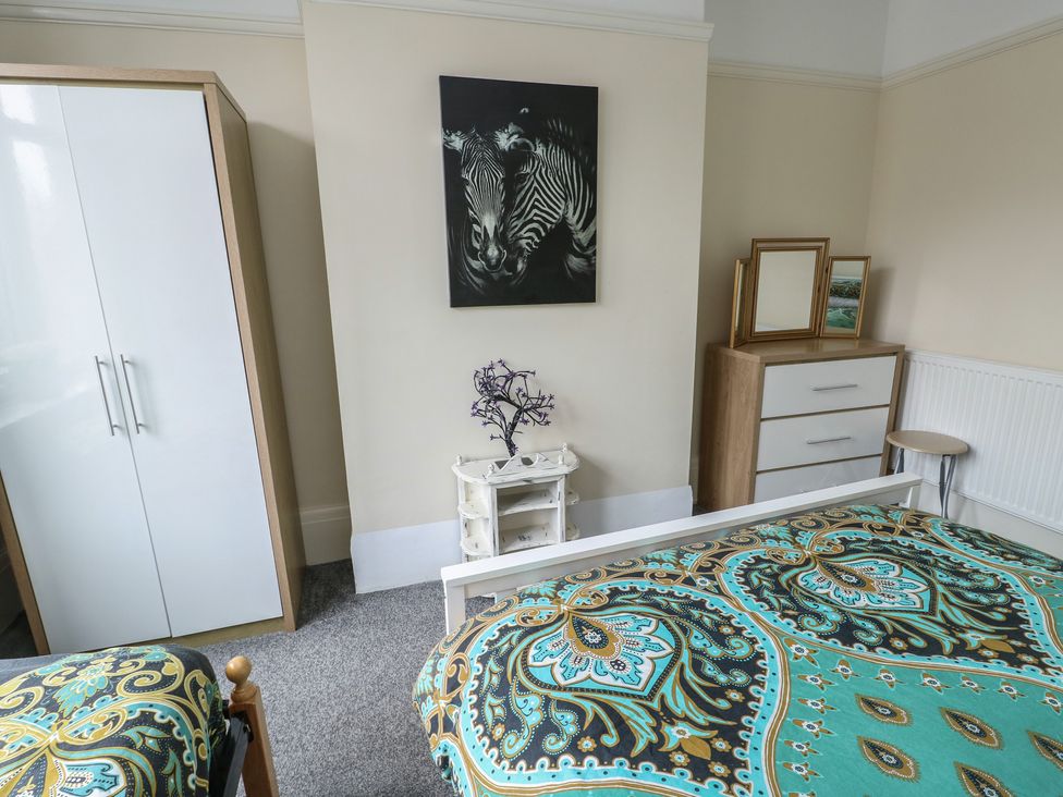 A bedroom with a bed and wardrobe at Sea Breeze in Rhos-on-Sea