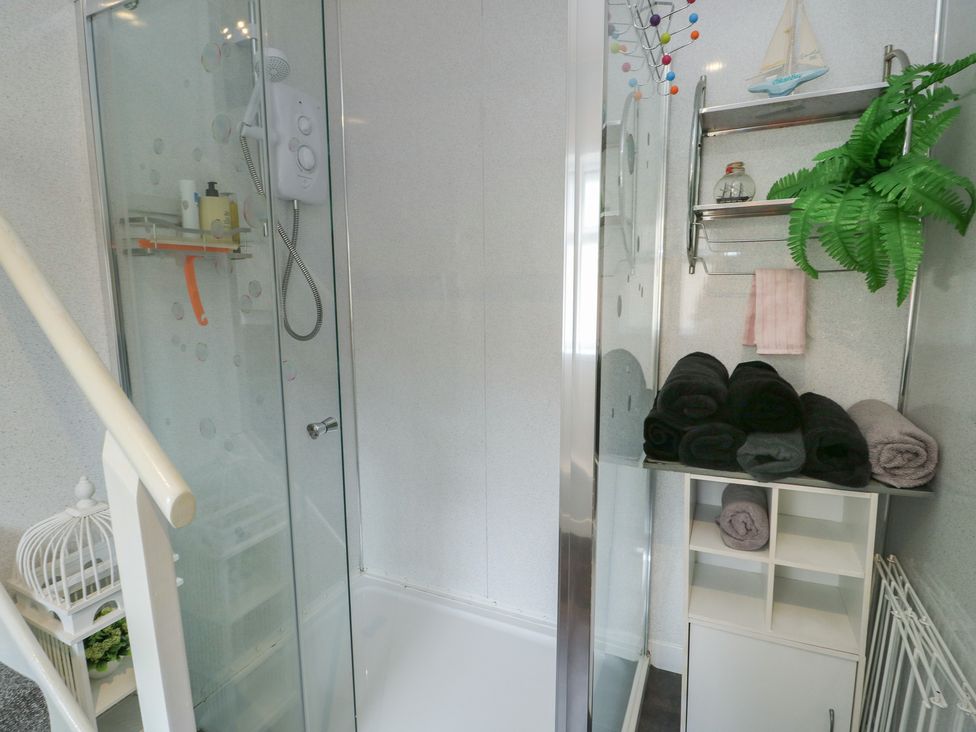 A shower area with towels and shelves at Sea Breeze in Rhos-on-Sea