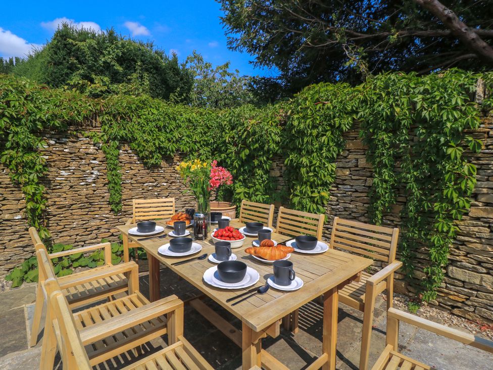 An outdoor dining area with a table and chairs at Easter Cottage in Burford