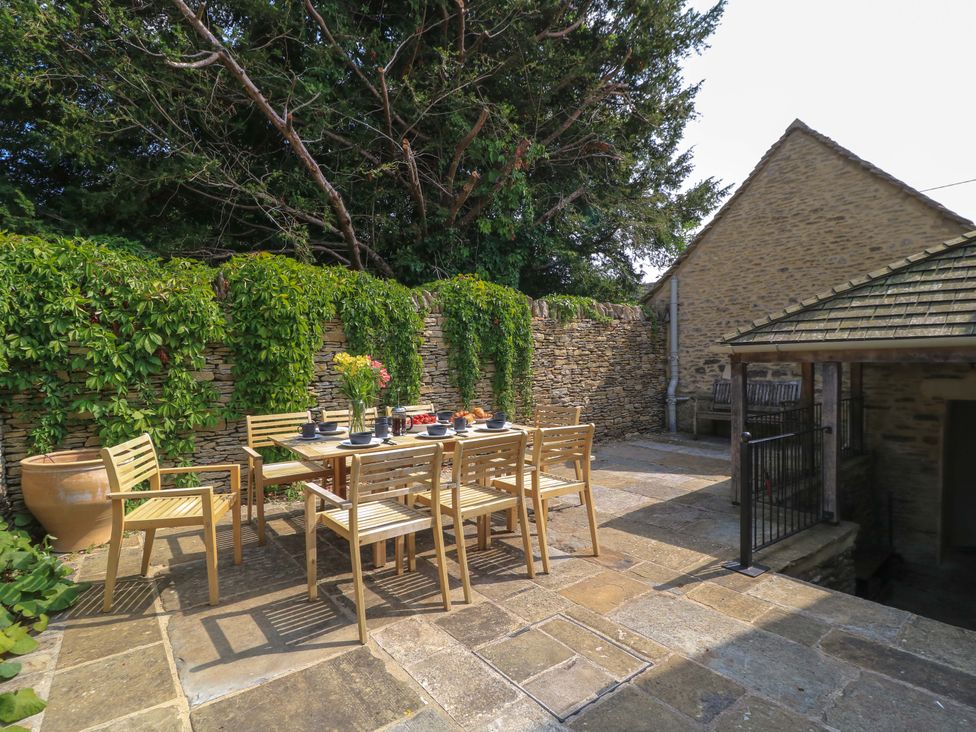 An outdoor dining area with a table and chairs at Easter Cottage in Burford