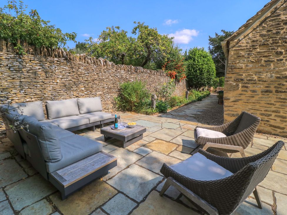 An outdoor seating area with a sofa and table at Easter Cottage in Burford