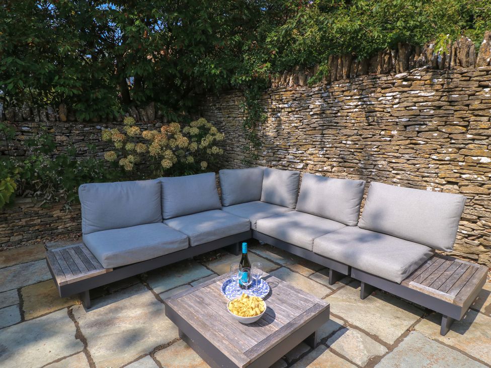 A garden with an outdoor sofa and coffee table at Easter Cottage in Burford