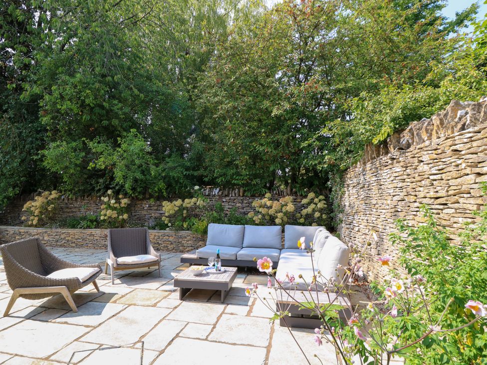 An outdoor seating area with a coffee table and flowers at Easter Cottage in Burford