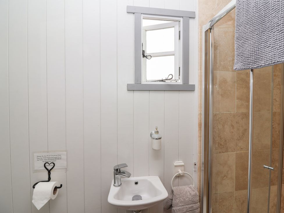 A bathroom with a sink and shower at The Shepherds Hut in Chippenham