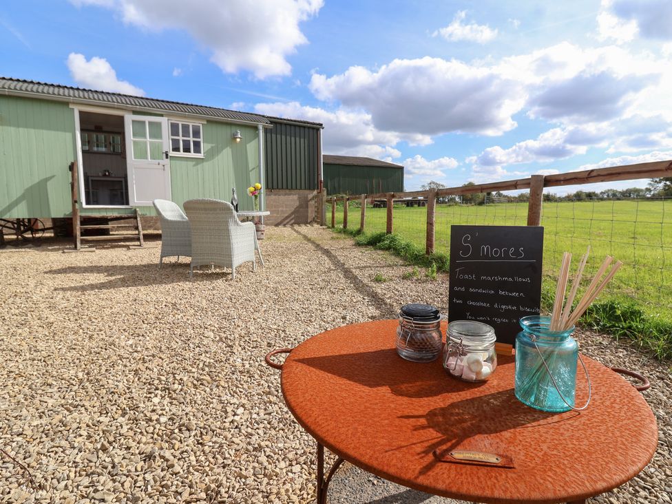 An outdoor area with a table and chairs at The Shepherds Hut in Chippenham