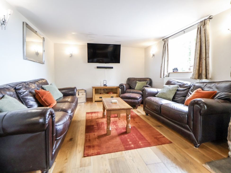 A living room with a sofa and television at The Farmhouse in Biddulph Moor near Biddulph