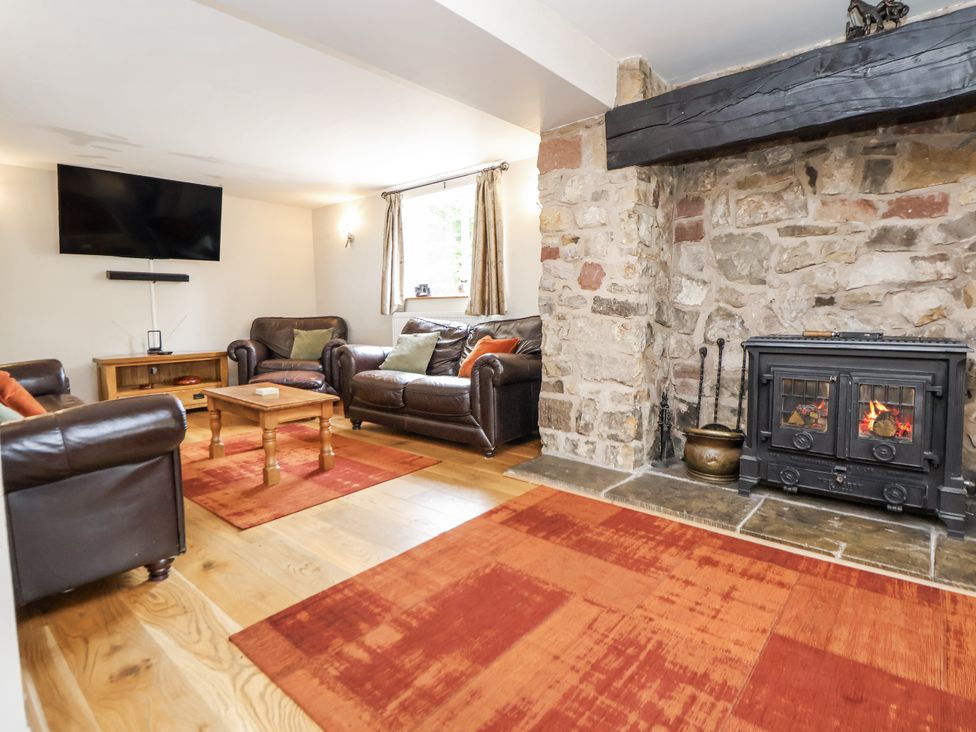 A living room with a television and a fireplace at The Farmhouse in Biddulph Moor near Biddulph