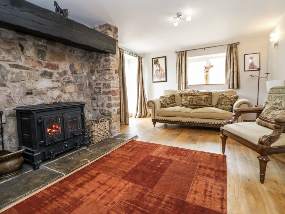 A living room with a fireplace and seating arrangements at The Farmhouse in Biddulph Moor near Biddulph