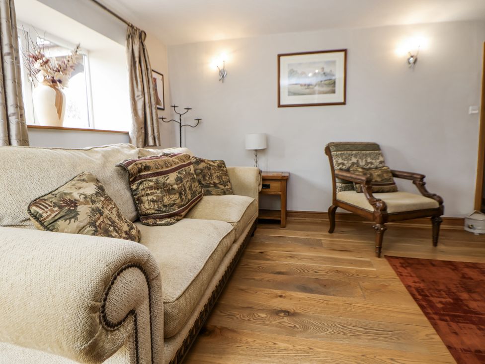 A living room with a sofa and armchair at The Farmhouse in Biddulph Moor near Biddulph