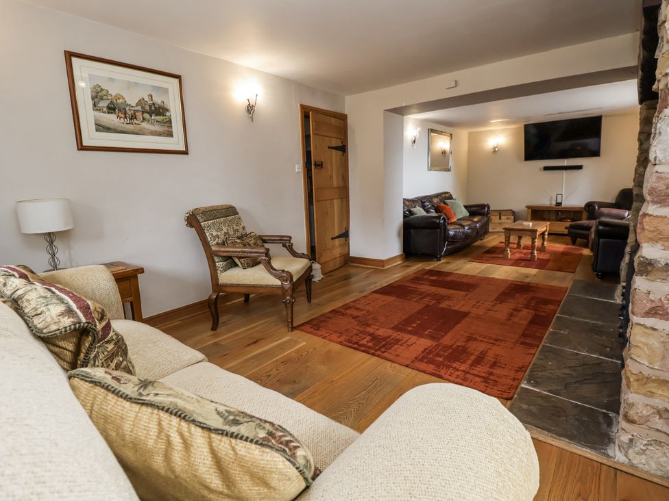 A living room with a sofa and an armchair at The Farmhouse in Biddulph Moor near Biddulph
