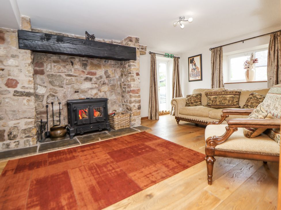 A living room with a fireplace and sofa at The Farmhouse in Biddulph Moor near Biddulph
